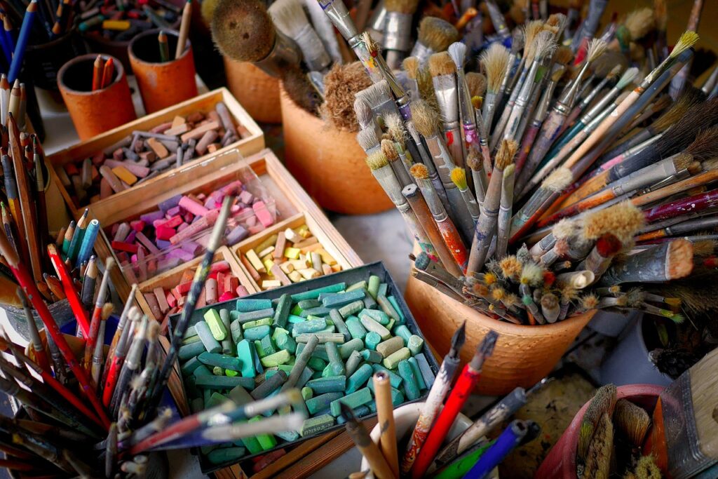 photo de plusieurs matériaux utilisés pour le dessin et la peinture : craies et pinceaux de toutes couleurs et forme