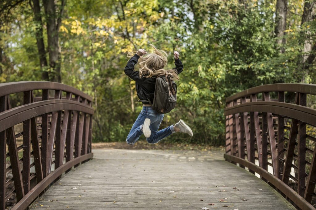 photo d'un ado sur un pont qui saute, les bras en l'air sans doute pour figurer sa joie.