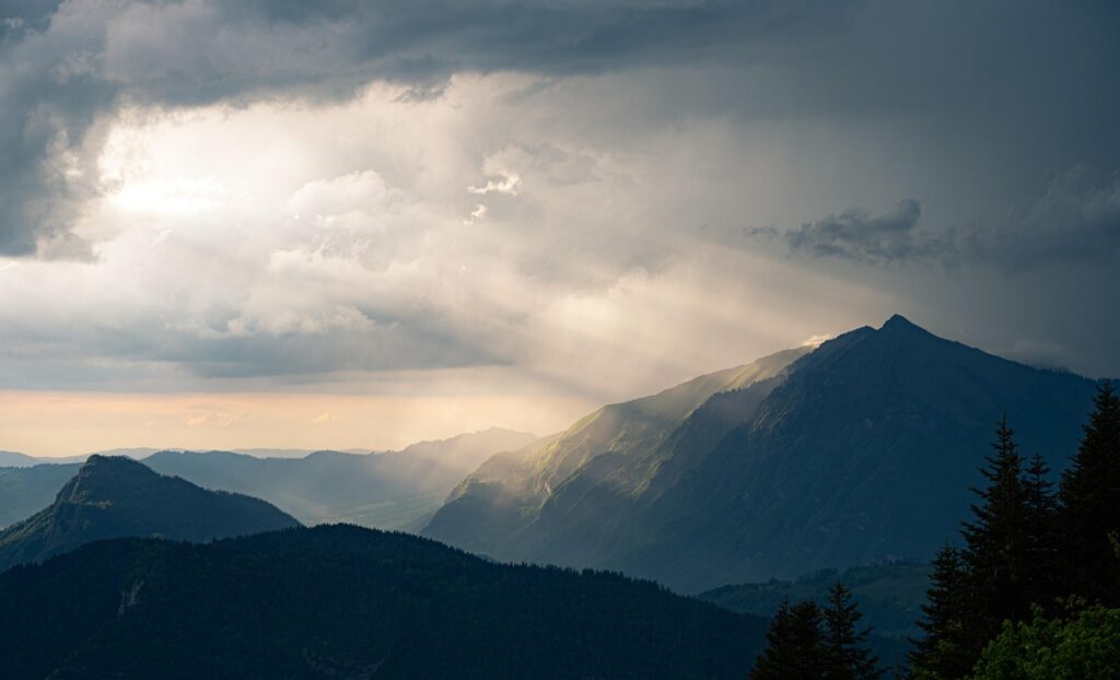 Photo de rayons de soleil qui percent les nuages pour illuminer un versant de montagne afin d'illustrer l'éclairage que la réponse à un entretien d'embauche peut être